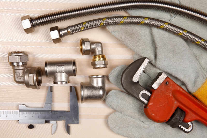 Plumber working on pipes in a West Ealing home